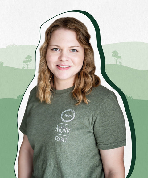 Limoment Teammitglied Isabel hat mittellange, gelockte, blonde Harre, grüne Augen, trägt ein grünes T-Shirt und lächelt.